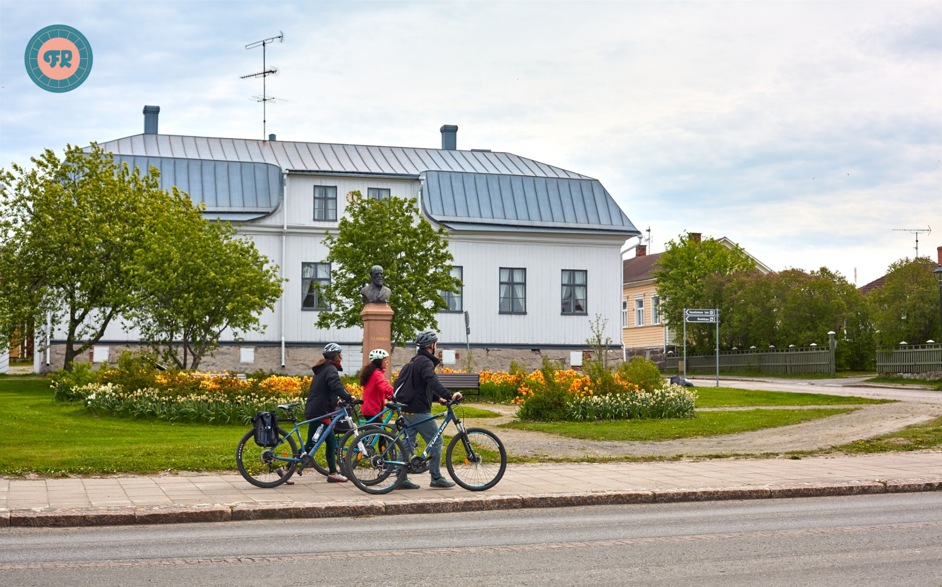 Cyclists walking their bikes on Rantakatu in Old Town Raahe.