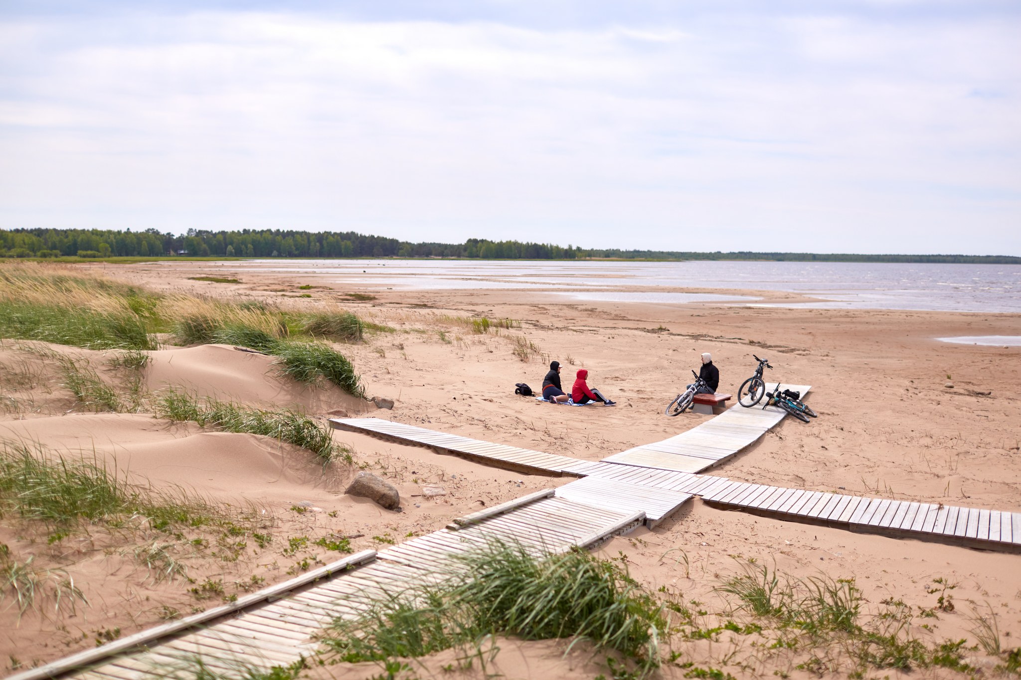 Pyöräilijöitä lepäämässä Tauvon hiekkarannalla.