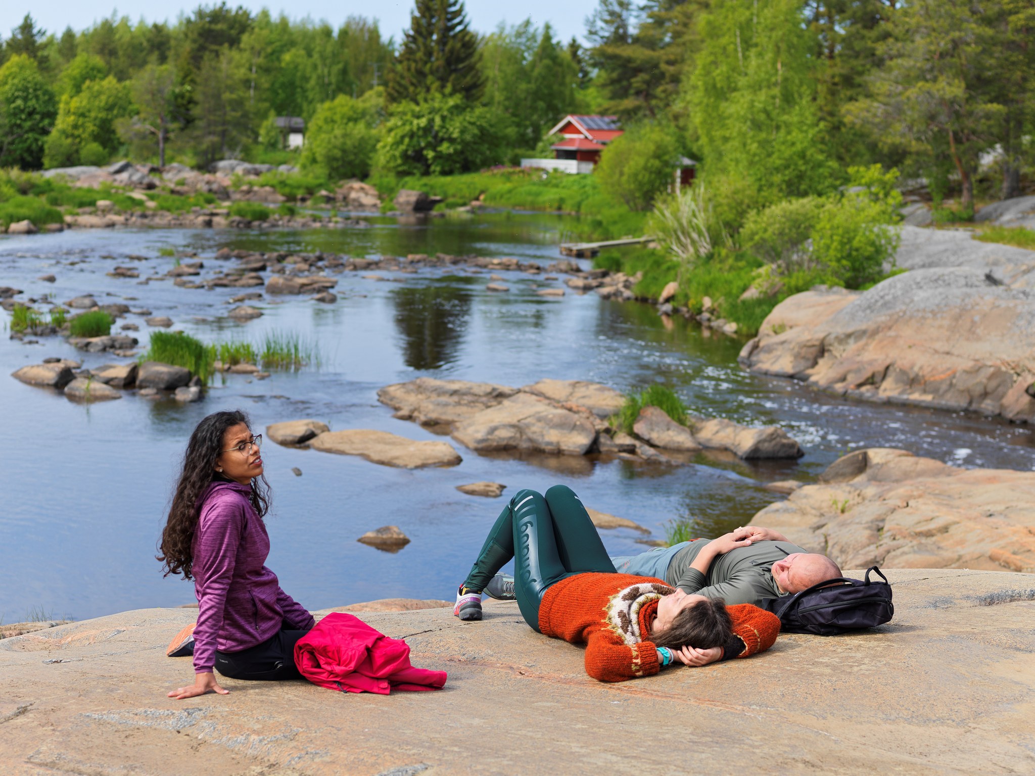 Henkilöitä makoilemassa kesäpäivänä Pyhäjoen Hourunkosken kallioilla.