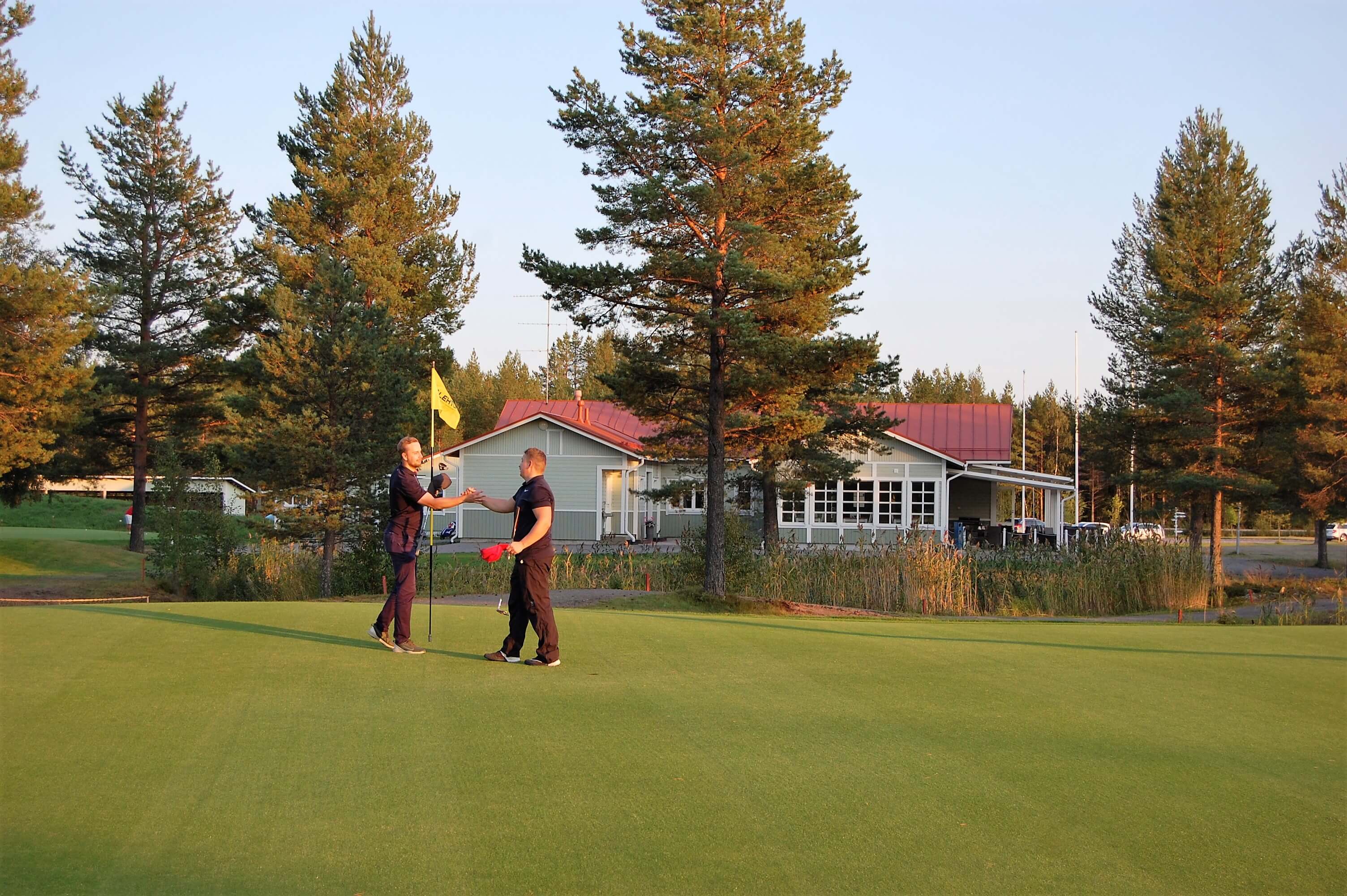 Kaksi henkilöä golfkentällä Raahentienoon Golfissa.