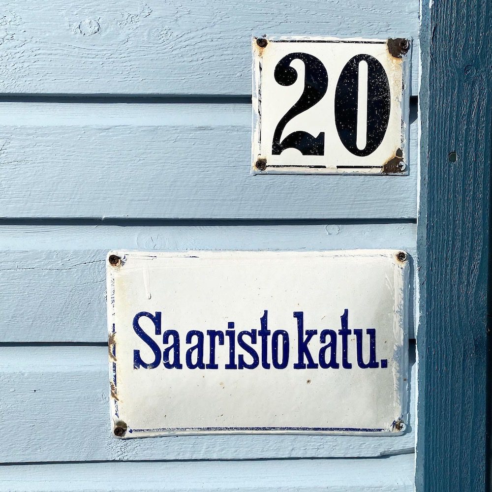 Vanhanaikainen katukyltti Wanhassa Raahessa vaalean sinisen talon seinässä