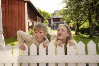 Iloisia lapsia nojaamassa puuaitaan Wanhassa Raahessa. 