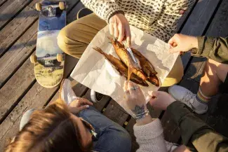 Three people eating fish. 