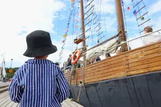 Raahe maritime festival boy in front of traditional sailing boat