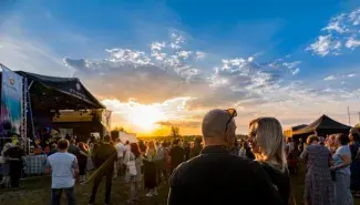 nainen ja mies auringolasku Raahe Festival yleisöä ympärillä